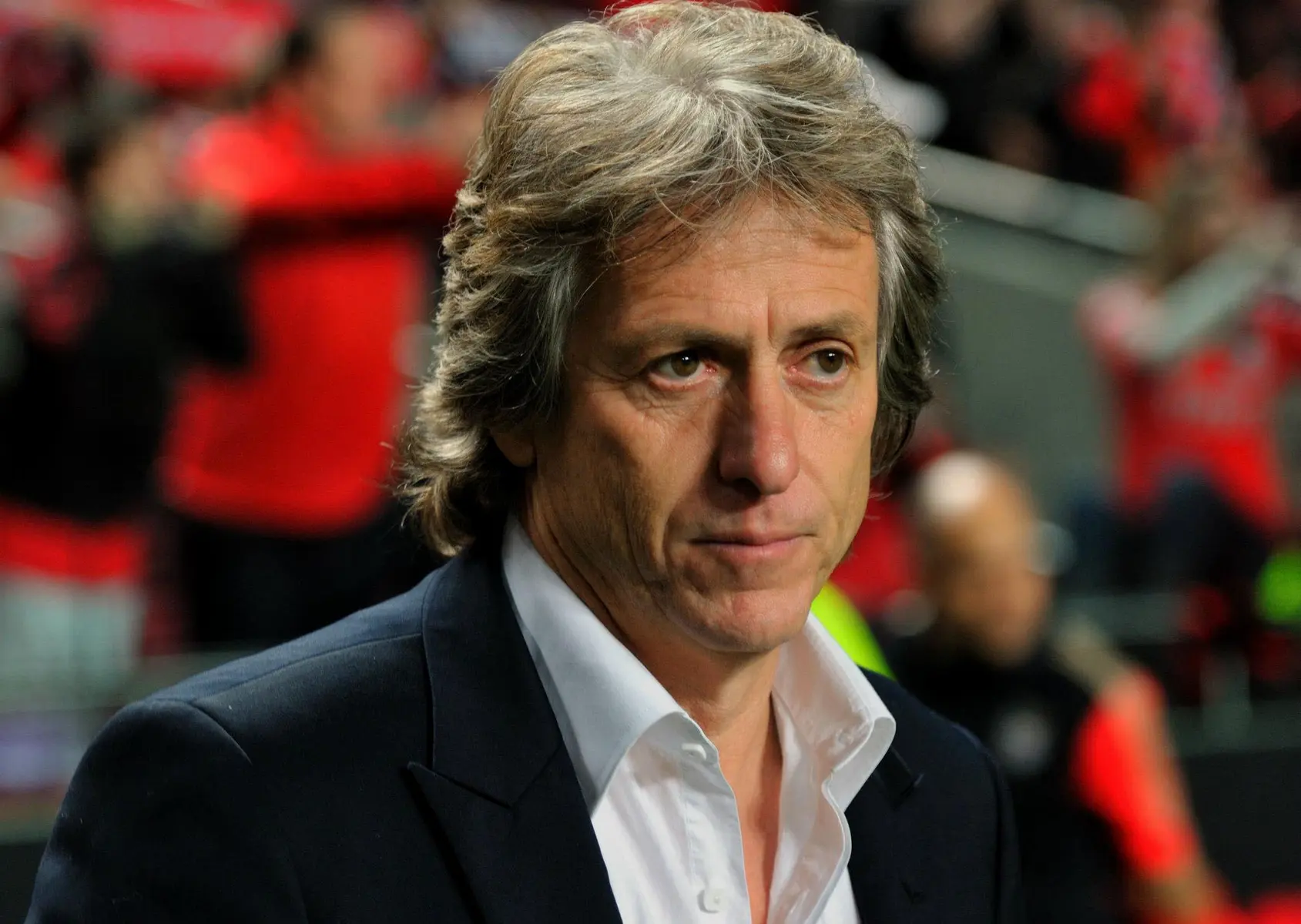 Retrato do treinador Jorge Jesus vestindo blazer escuro e camisa branca.